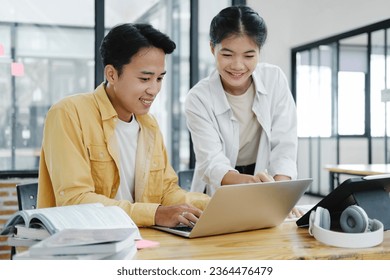 Learning, education and school concept. Young woman and man studying for a test or an exam. Tutor books with friends. Young students campus helps friend catching up and learning. - Shutterstock ID 2364476479
