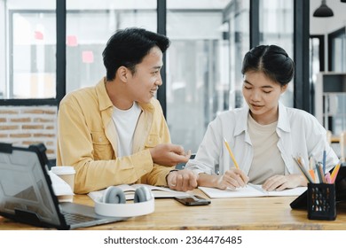 Learning, education and school concept. Young woman and man studying for a test or an exam. Tutor books with friends. Young students campus helps friend catching up and learning. - Shutterstock ID 2364476485