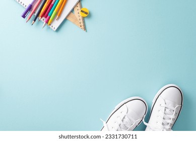 Learning essentials composition. Creative top view photograph featuring a pair of sneakers and an array of educational supplies on a pastel blue background. Ideal for text or promotional content