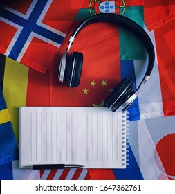 Learning foreign languages. Audio language courses. Background from countries flags and headphones on table.