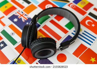 Learning foreign languages online. Headphones and countries flags on the background.