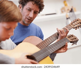 Learning, guitar and teacher in music with child in lesson and development of skill on instrument. Playing, practice and man helping kid in education with advice as musician mentor in acoustic sound - Powered by Shutterstock