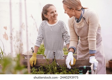 Learning, happy mother and kid gardening with plants, help or family bonding together outdoor in summer. Mom, girl and smile for vegetables, agriculture or growth of organic food in box at backyard - Powered by Shutterstock