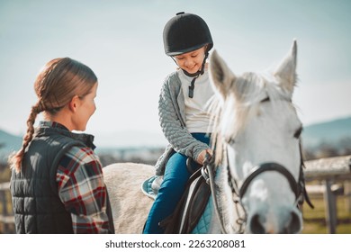 Learning, hobby and girl on a horse with a woman for fun activity in the countryside of Italy. Happy, animal and teacher teaching a child horseback riding on a field as an equestrian sport in nature - Powered by Shutterstock