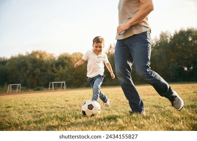 Learning how to play soccer. Father and little son are having fun outdoors. - Powered by Shutterstock