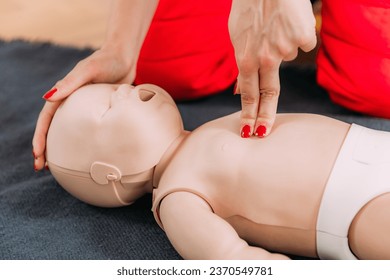 Learning infant CPR in a first aid training - cardiopulmonary resuscitation course using a baby dummy. - Powered by Shutterstock