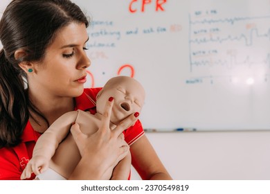 Learning infant CPR in a first aid training - cardiopulmonary resuscitation course using a baby dummy. - Powered by Shutterstock