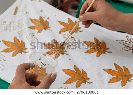 Learning to make Indonesian batik. A workshop of batik painting on white fabric	