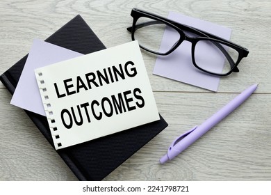 LEARNING OUTCOMES text on paper on wooden background. - Shutterstock ID 2241798721