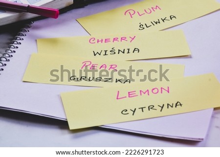 Learning Polish with fruits name on flash cards; English to Polish language translation. Selective focus.