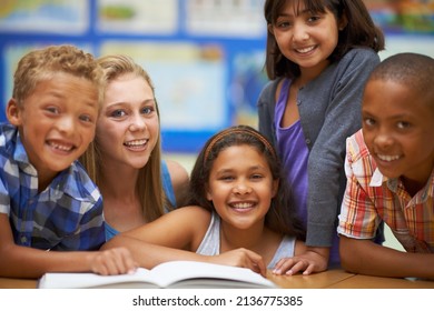 Learning to read and loving it. Portrait of a group of pupils reading from a book in class. - Powered by Shutterstock