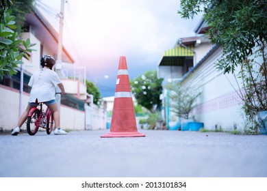 Learning To Ride A Bike Concept, The Little Boy Is Practicing Cycling A Bicycle With The Training Wheels On The Road.