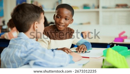 Learning, students and friends in classroom for knowledge, test and writing exam or study. Kids, talking and team in lesson for education or children for conversation and talk together at school