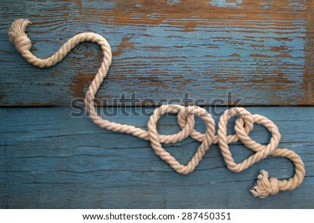 leash  rope into heart shape on wooden table 