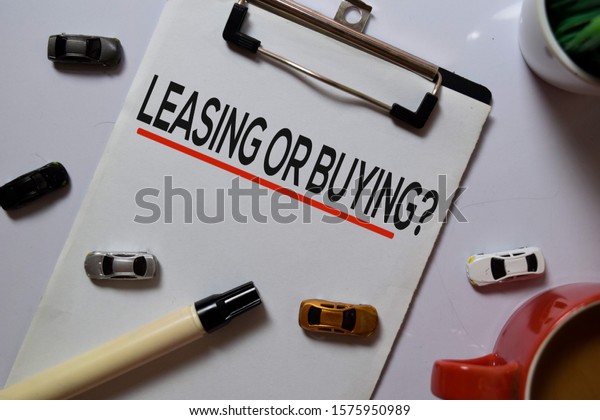 Leasing or Buying? write on Paperwork with\
Car toys isolated on white board\
background.