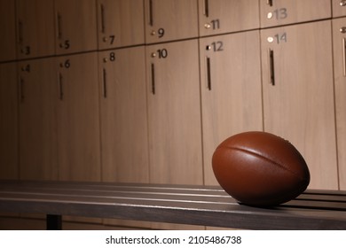 Leather American football ball on wooden bench in locker room. Space for text - Powered by Shutterstock