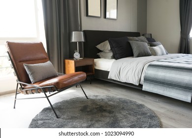 leather armchair and gray carpet in bedroom