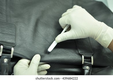 Leather Bag Cleaning In Leather Factory. A Man Cleaning A Black Leather Bag With A Brush To Remove Spots On It.