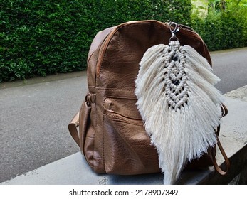 A Leather Bag With Macrame Feather As Its Decoration. 