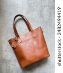 Leather bag on grey background. Women accesories with brown color bag. Tas wanita