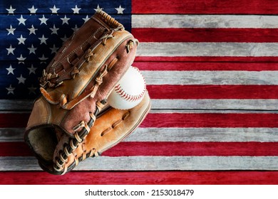 Leather baseball or softball glove with ball on rustic wooden background with painted US flag and copy space. - Powered by Shutterstock