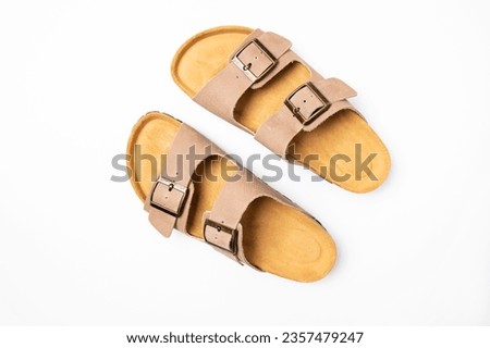 Leather beige sandals birkenstocks on white background top view flat lay. Unisex summer shoes, genuine leather flip flops with cork soles. Stylish fashion footwear, mockup for design