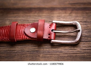 Leather Belt On A Wooden Background. Girdle Of Red Leather. 