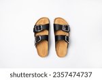 Leather black sandals birkenstocks on white background top view flat lay. Unisex summer shoes, genuine leather flip flops with cork soles. Stylish fashion footwear for city or beach