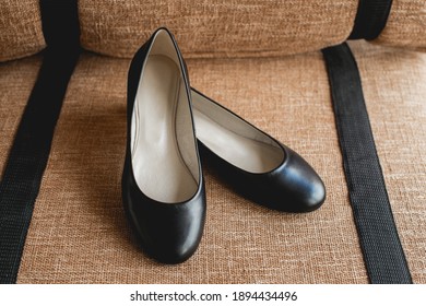 Leather black women's shoes on a brown fabric. fashion concept, women's shoes, accessories.