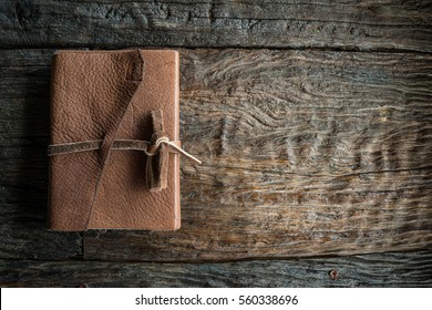 The leather book on the wood table.