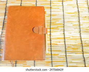 Leather Bound Book On Mat Wood