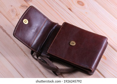 Leather Brown Purse For Documents And A Mobile Phone Lies On A Wooden Table Close-up