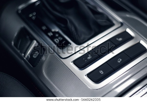 Leather car interior. Modern car illuminated\
dashboard. Luxurious car instrument cluster. Close up shot of\
automobile instrument panel. Modern car interior dashboard.\
Electric hand brake
