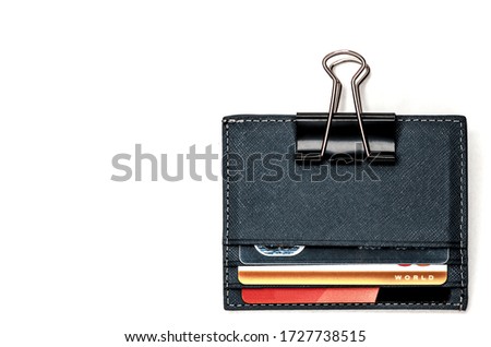 Leather cardholder with credit cards on a white background. Cardholder clamped by a paper clip. The symbol of the electronic wallet