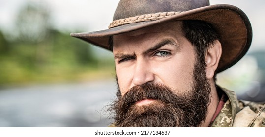 Leather Cowboy Hat. Portrait of young man wearing cowboy hat. Cowboys in hat. Handsome bearded macho. Man unshaven cowboys. American cowboy.