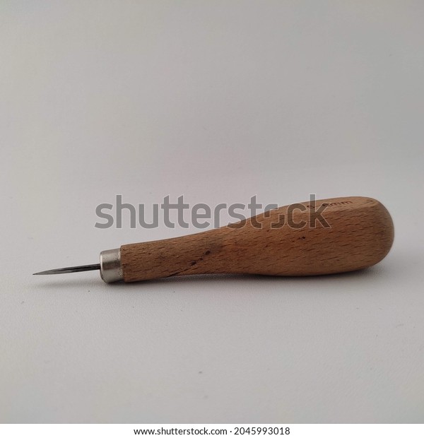 leather craft tool - diamond\
awl with sharp wooden handle for leather craft isolated on white\
background