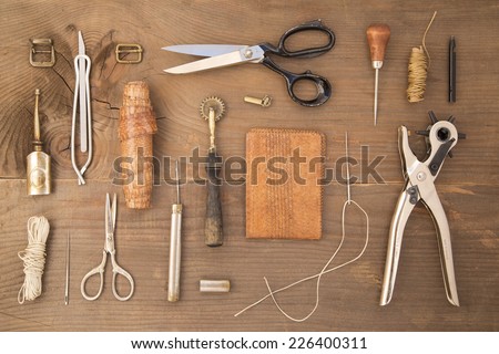 Leather craft tools on a wooden background