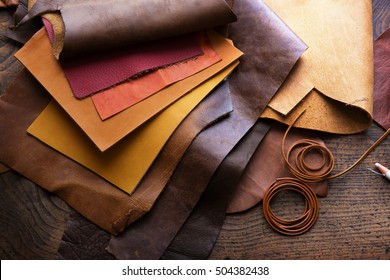 Leather craft or leather working. Selected pieces of beautifully colored or tanned leather on leather craftman's work desk.
