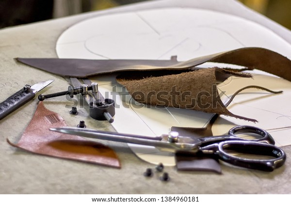 Leather crafting DIY tools and templates
on workbench. Fittings and leather pieces with craft instruments
for leather items
manufacturing.