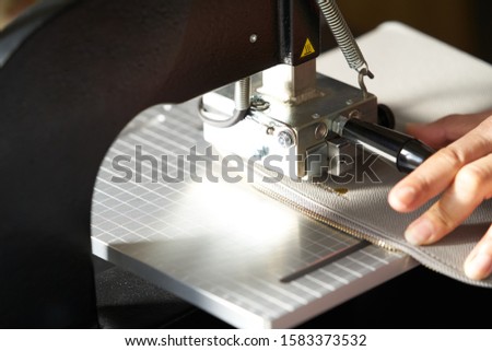 Leather crafting with leather engraving machine. Working process of making leather wallet in the leather workshop, close-up. 