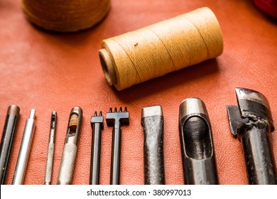 Leather crafting tools on work table with tan color genuine leather