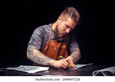 Leather Craftsman processing a leather workpiece in his tanner shop