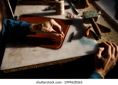 A leather craftsman works in a workshop