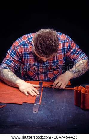 Leather Currier processing a leather workpiece at his studio