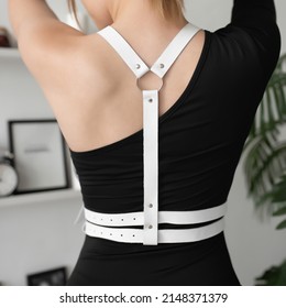 Leather detail on the model. Stylish belts on clothes. White leather harness. Back view. Russia, Rostov-on-Don 7june2021
