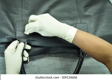 A Leather Factory Worker Cleaning A Black Leather Bag With Cleaning Cloth. The Hands Of The Worker Covered With Gloves And Rubbing The Lather Beg With A Microfiber Cotton Cloth. 