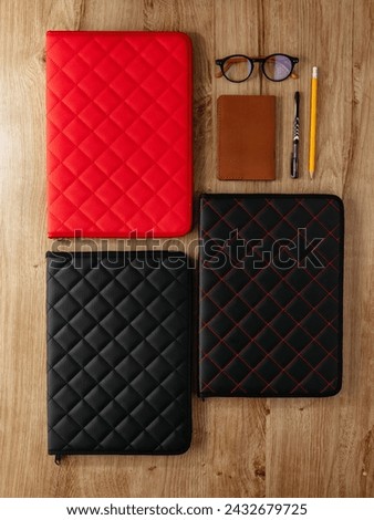 a leather folder for documents lies on the table next to the acc