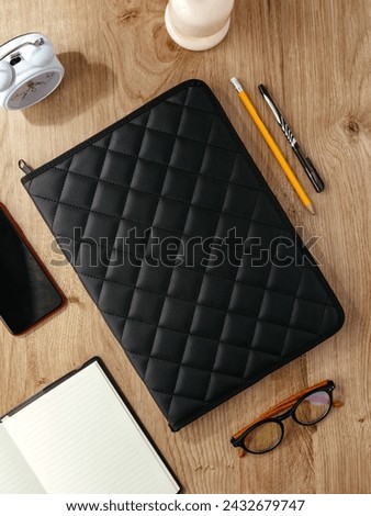 a leather folder for documents lies on the table next to the acc