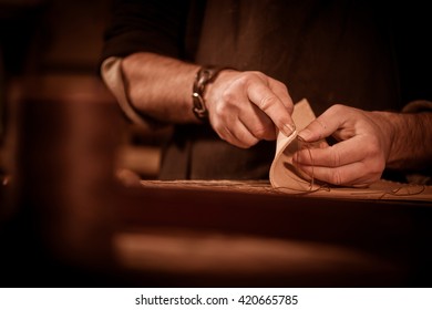 Leather goods craftsman at work in his workshop, France - Powered by Shutterstock