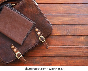 Leather hand bag with notepad on old wooden background